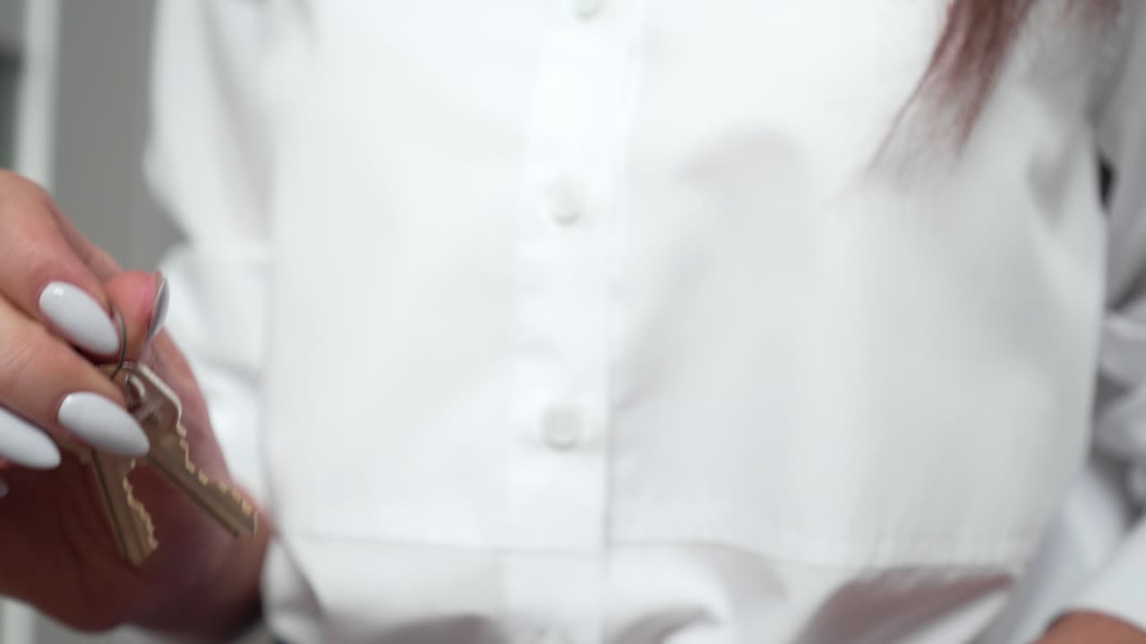 mujer agente inmobiliaria con uñas largas y hermosas sosteniendo las llaves de la casa en sus manos