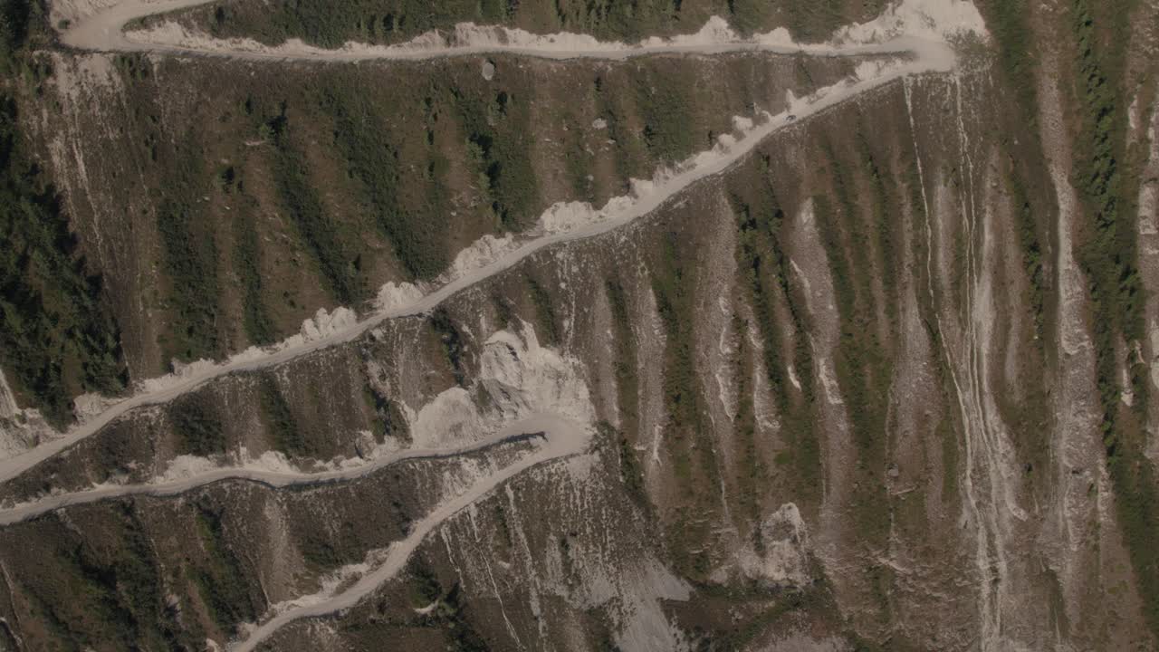 Riprese con drone della ripida strada sterrata a zig-zag che scende dal Passo Katu-Yaryk nella Valle di Chulyshman, Repubblica dell'Altai, Russia, paesaggio montano spettacolare