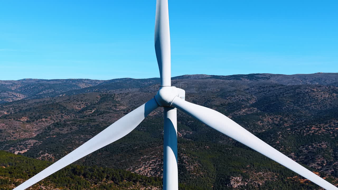 Madrid, Spagna, 8 agosto 2025: Primo piano della navicella e delle pale di una turbina eolica. Vista dettagliata del rotore e delle pale della turbina eolica su uno sfondo di valle montuosa e colline sfumate.