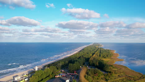 aerial view rising above long green forest resort island landscape, wladyslawowo, poland