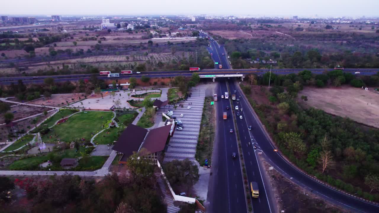 National highway with oxygen birds park and vehicles at jamtha, nagpur, maharashtra, india. sun set time, down shot, drone shot, 4k.