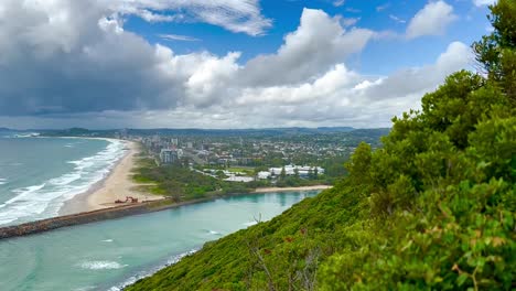 Cabezas-De-Burleigh,-Costa-Dorada-Con-Playa-Y-Arroyo-Tallebudgera---Mirando-Hacia-Abajo-Desde-El-Mirador-De-La-Selva-Tropical-Hasta-La-Costa-Sobre-La-Entrada-Del-Río-Con-Nubes-Hinchadas