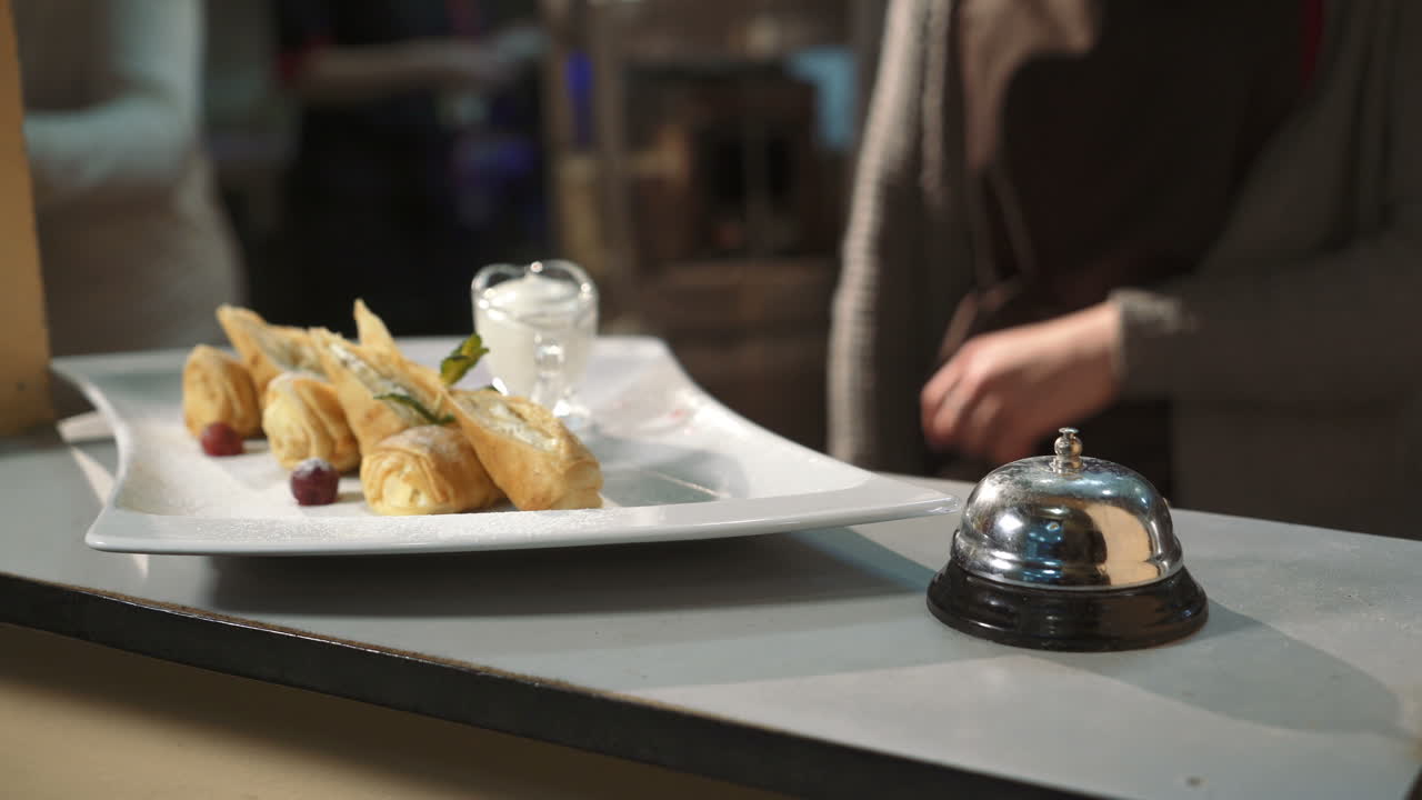 Waiter serving dessert at restaurant. Waiter holding plate of dessert in restaurant