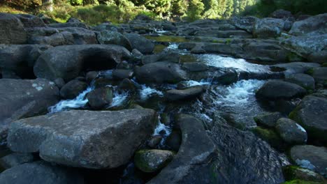 serene stream of fresh mountain water flowing through rocky stone riverbed, new zealand