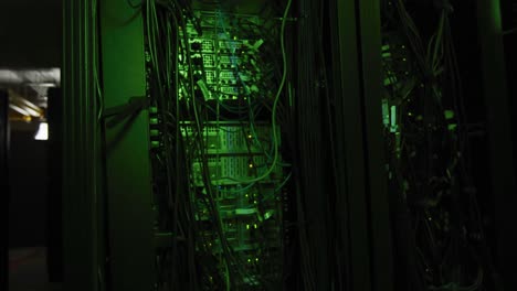 green control lights and multiple cables on computer servers in tech room