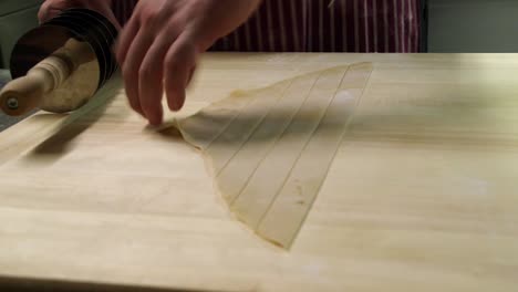 Preparing-stripes-of-fresh-pasta-with-a-cutting-rolling-pin