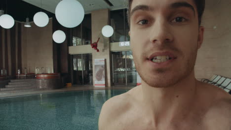 handsome man face telling camera in spa. smiling guy recording video at resort