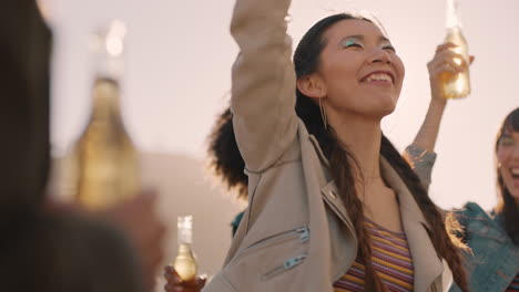 group of multiracial friends hanging out young asian woman dancing enjoying rooftop party at sunset drinking having fun on weekend celebration