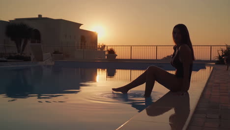 woman enjoying a beautiful sunset by the swimming pool