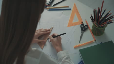 unrecognizable female teacher drawing geometric shapes at her desk