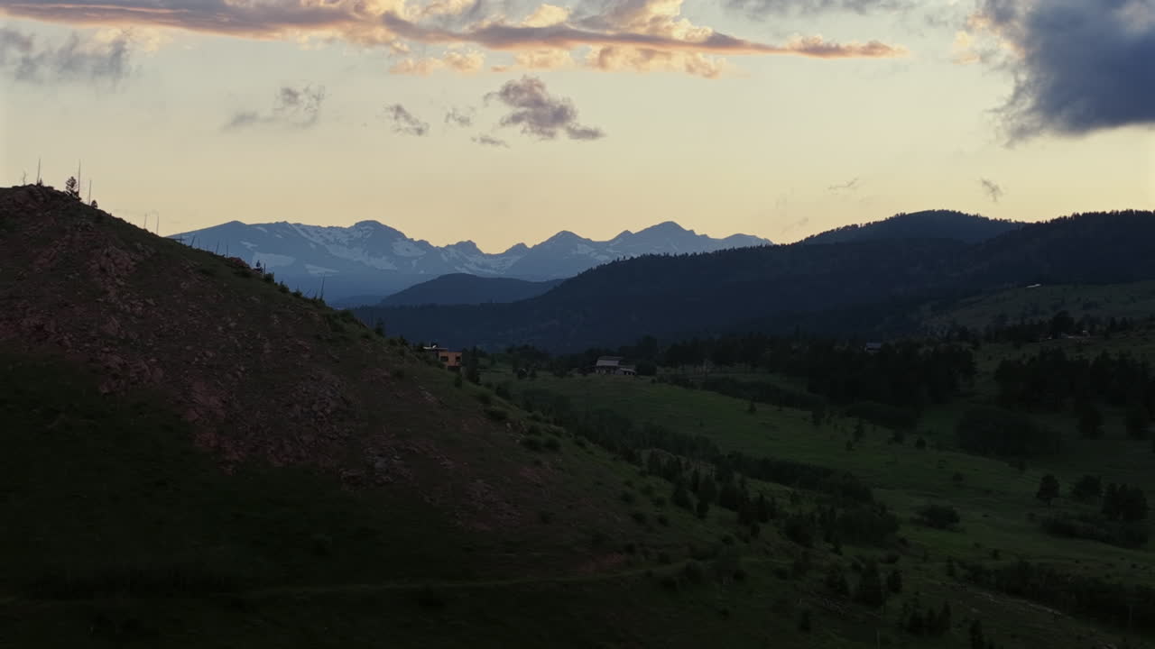 Drone footage of a summer sunset over the mountains near Boulder, Colorado. Aerial view of scenic wilderness, ridges, and forested landscapes