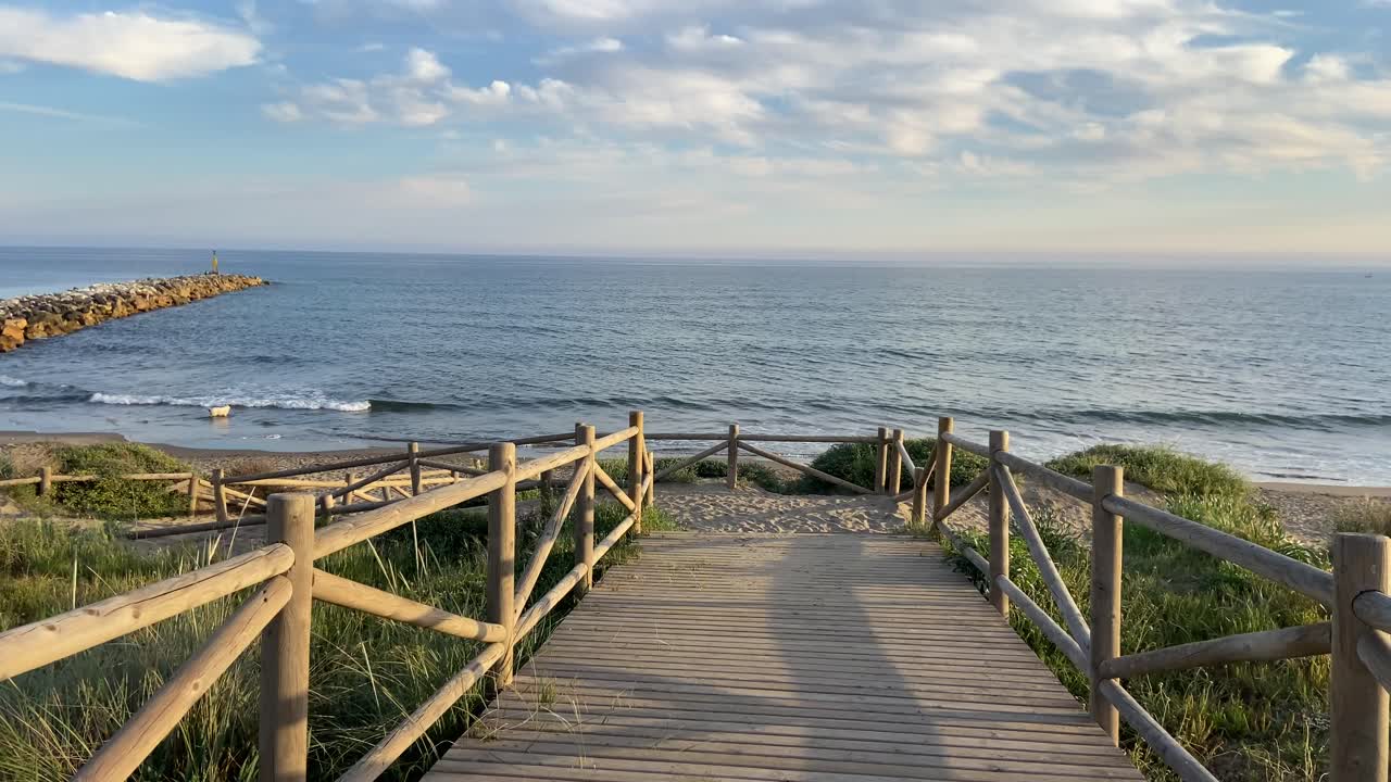 Walking along the shore of a beach under a warm and magical sunset in southern Spain.