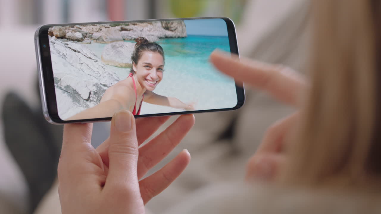 mujer joven chateando en video usando un teléfono inteligente amiga feliz en una playa de vacaciones en italia compartiendo experiencia de viaje divirtiéndose en vacaciones comunicándose con el teléfono móvil 4k