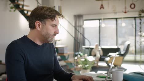 attractive man typing on compöuter and drinking coffee