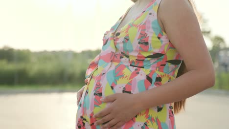 pregnant girl walks in a beautiful dress and hat