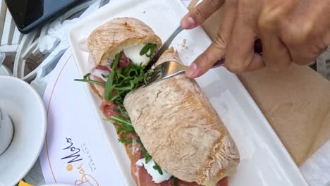 hands preparing a sandwich with fresh ingredients