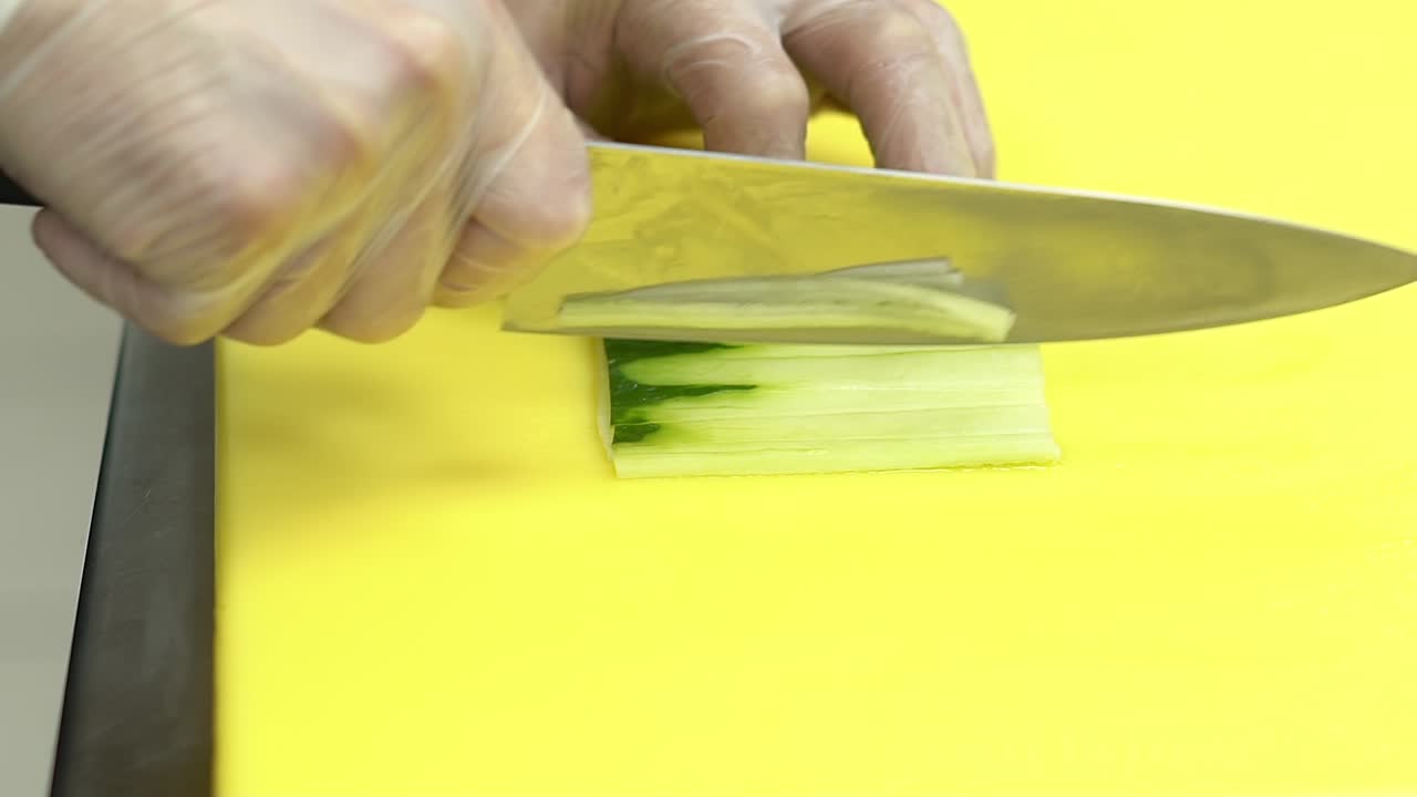 Cook quickly cuts fresh cucumber strips