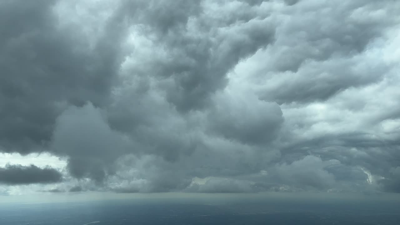 거대한  ⁇ 루니 ⁇ 스 구름의 바닥 근처를 날아다니는 비행기 객실에서 극적인 하늘 풍경