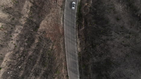 Vista-Aérea-De-La-Conducción-De-Automóviles-A-Través-De-Bosques-Quemados,-Alejándose