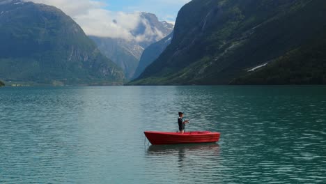 Una-Mujer-En-El-Barco-Pesca-Un-Pez-Girando-En-Noruega.