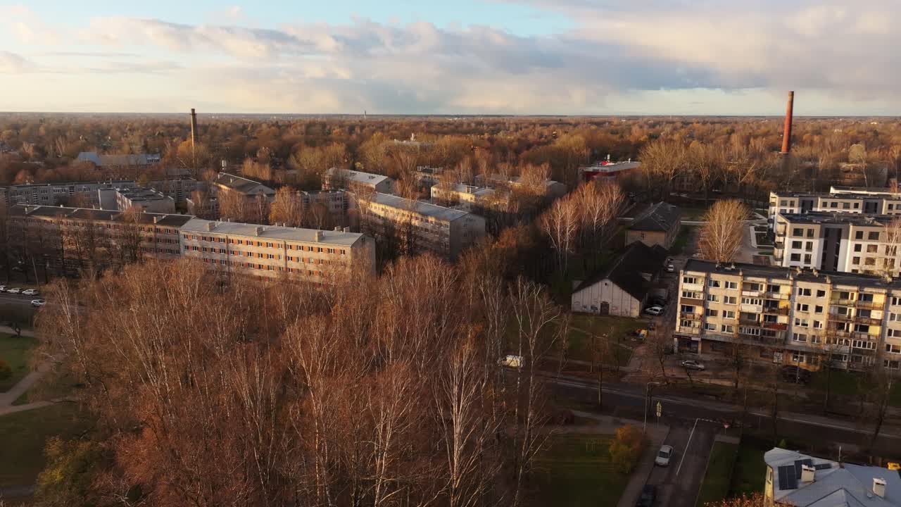 Soviet-era apartments in Agenskalns with golden autumn trees at sunset