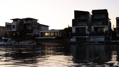 a boat moves along a canal at sunset