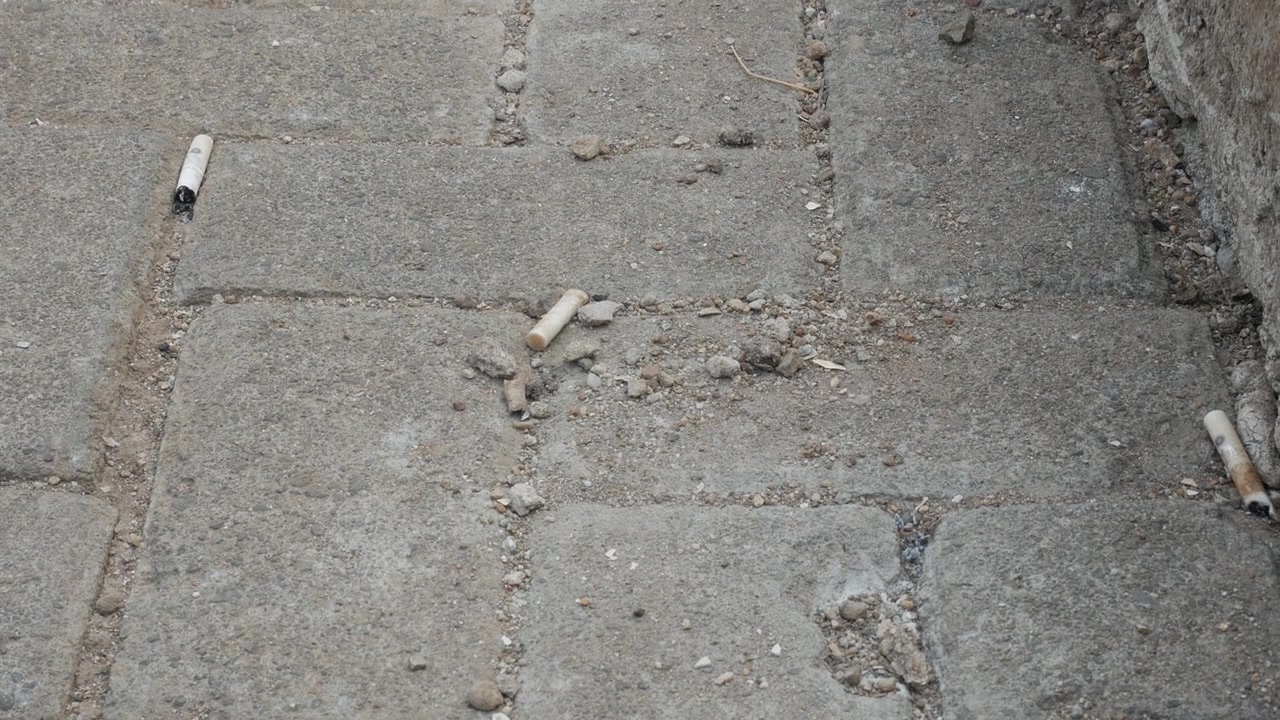 Mozziconi di sigaretta abbandonati su blocchi di cemento pavimentati
