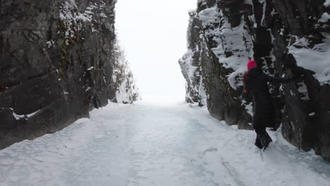 girl walking on ice and snow in a big cave in björkliden, sweden