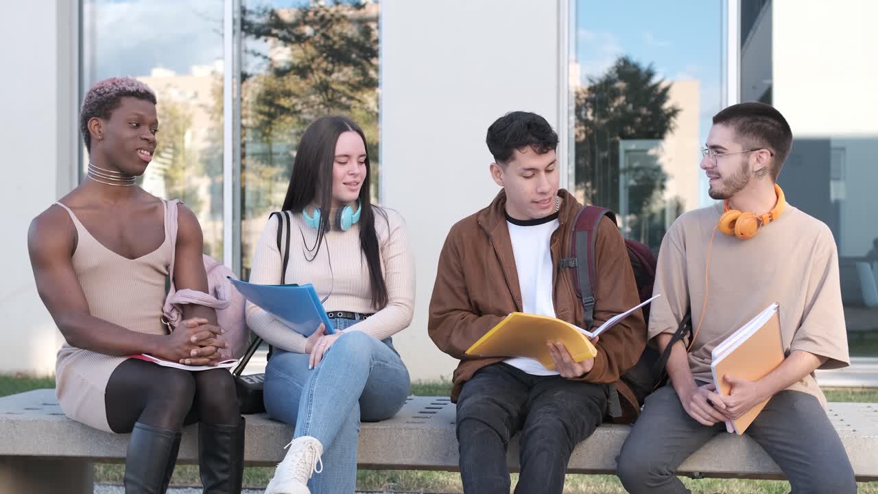 Group of friends sitting in line outside the university discussing class notes