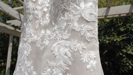 hermosa revelación de cerca del diseño material de un vestido de novia de moda afuera durante el verano en el centro de bodas y eventos strathmere en ottawa, canadá