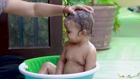 toddler enjoying bathing with shampoo and soap in tub at outdoor from unique perspective