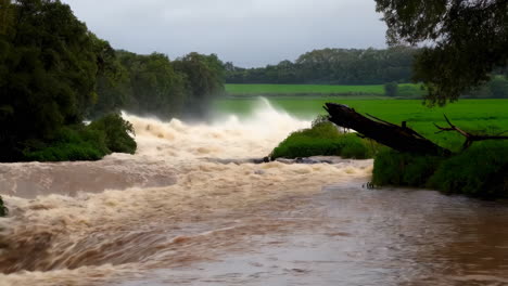 flooded river with waterfall