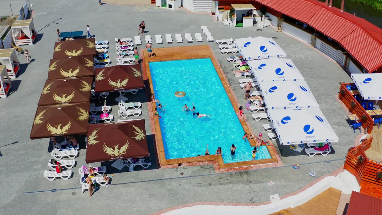 People relaxing in swimming pool. Aerial drone view from above of swimming pool