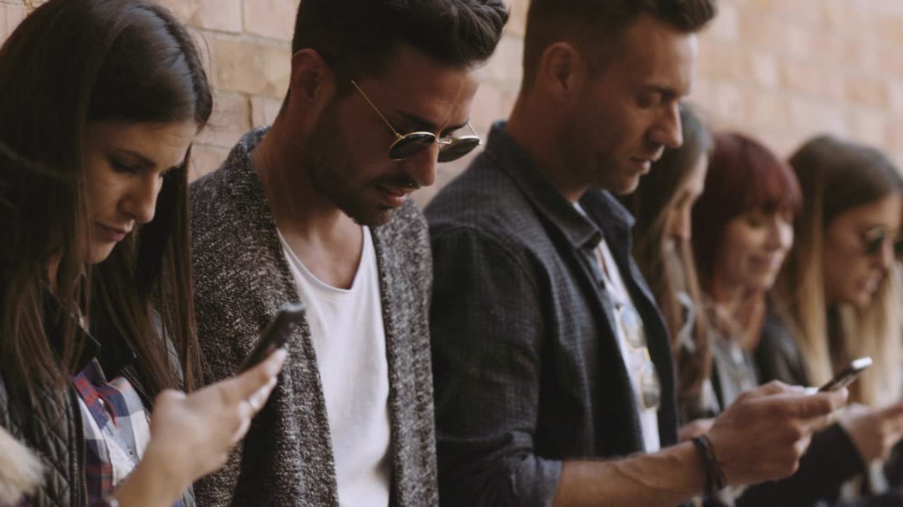 gran grupo de amigos usando el teléfono celular. disparado en cámara lenta