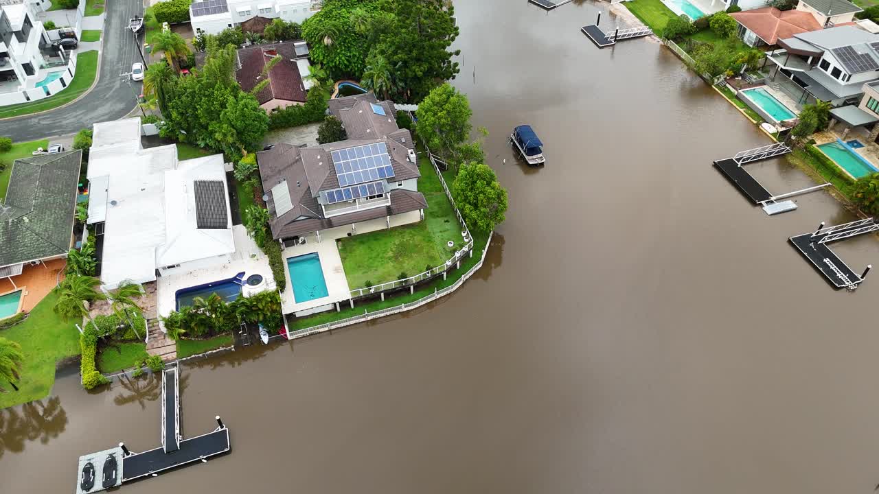 Drone footage captures a flooded residential area in Gold Coast, Australia, highlighting submerged streets and rising water levels