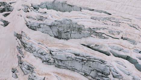 valmalenco, italy - a thick layer of ice enveloping the rugged terrain of the fellaria glacier - zoom in shot