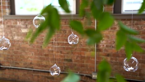 Many-small-candles-hanging-in-glass-lamps-inside-a-brick-building