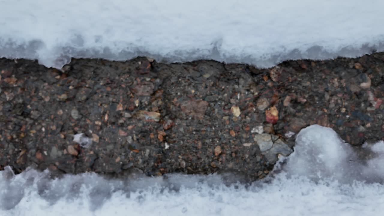 Melted ice water flowing in slow motion. Slider shot with blured ice and rain drops