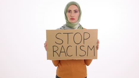 woman in hijab holding a 'stop racism' sign