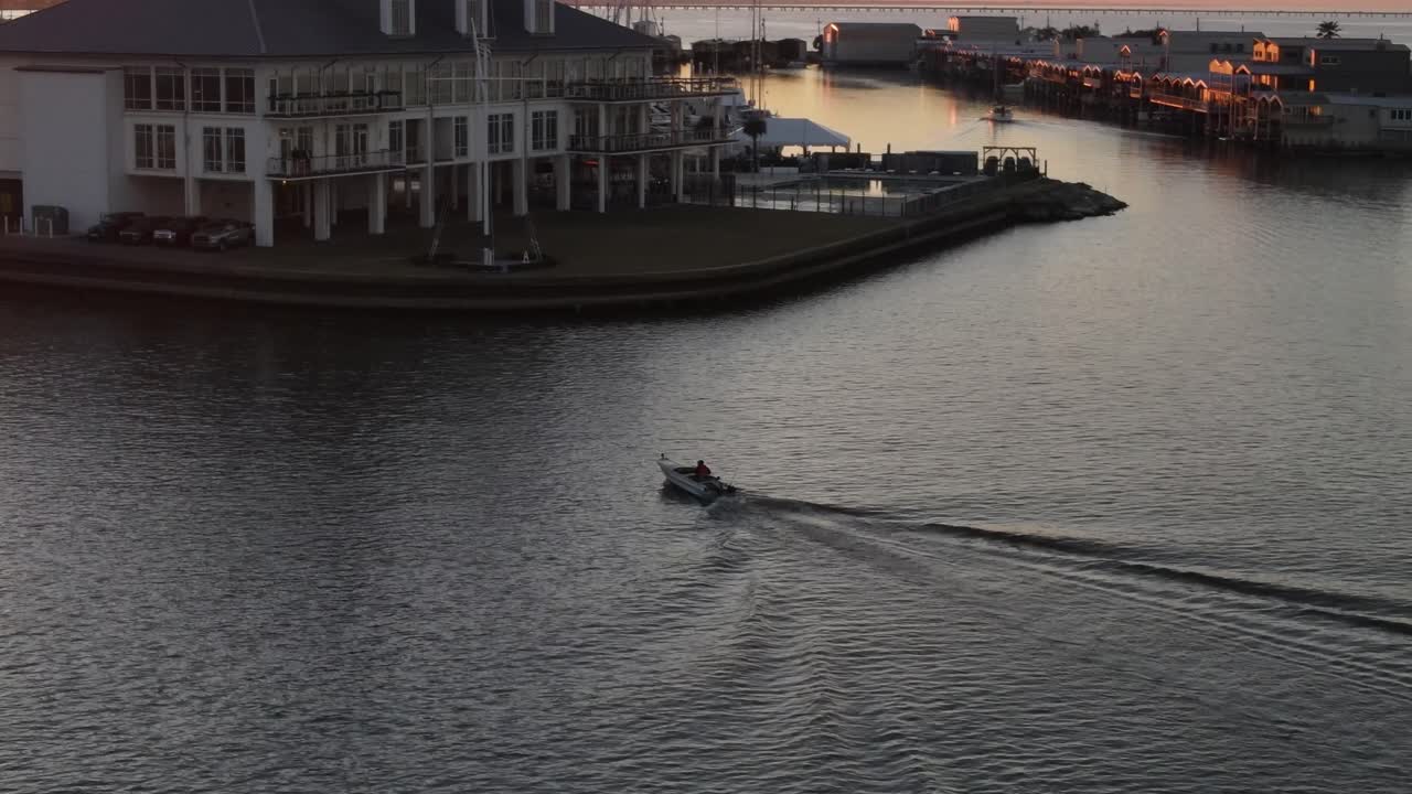 Speedboat Travels Down Toward The Southern Yacht Club Building At Dusk In New Orleans, USA, aerial