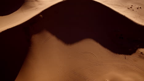 surreal drone angle looking directly down on the wave-like formations of pink sand.