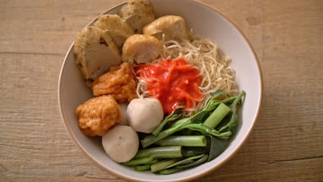 egg noodles with fish balls and shrimp balls in pink sauce, yen ta four or yen ta fo - asian food style