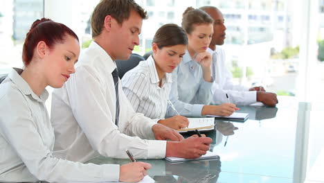 business team taking notes in a meeting together