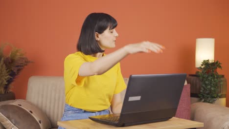 mujer cerrando la computadora portátil con expresión de enojo.