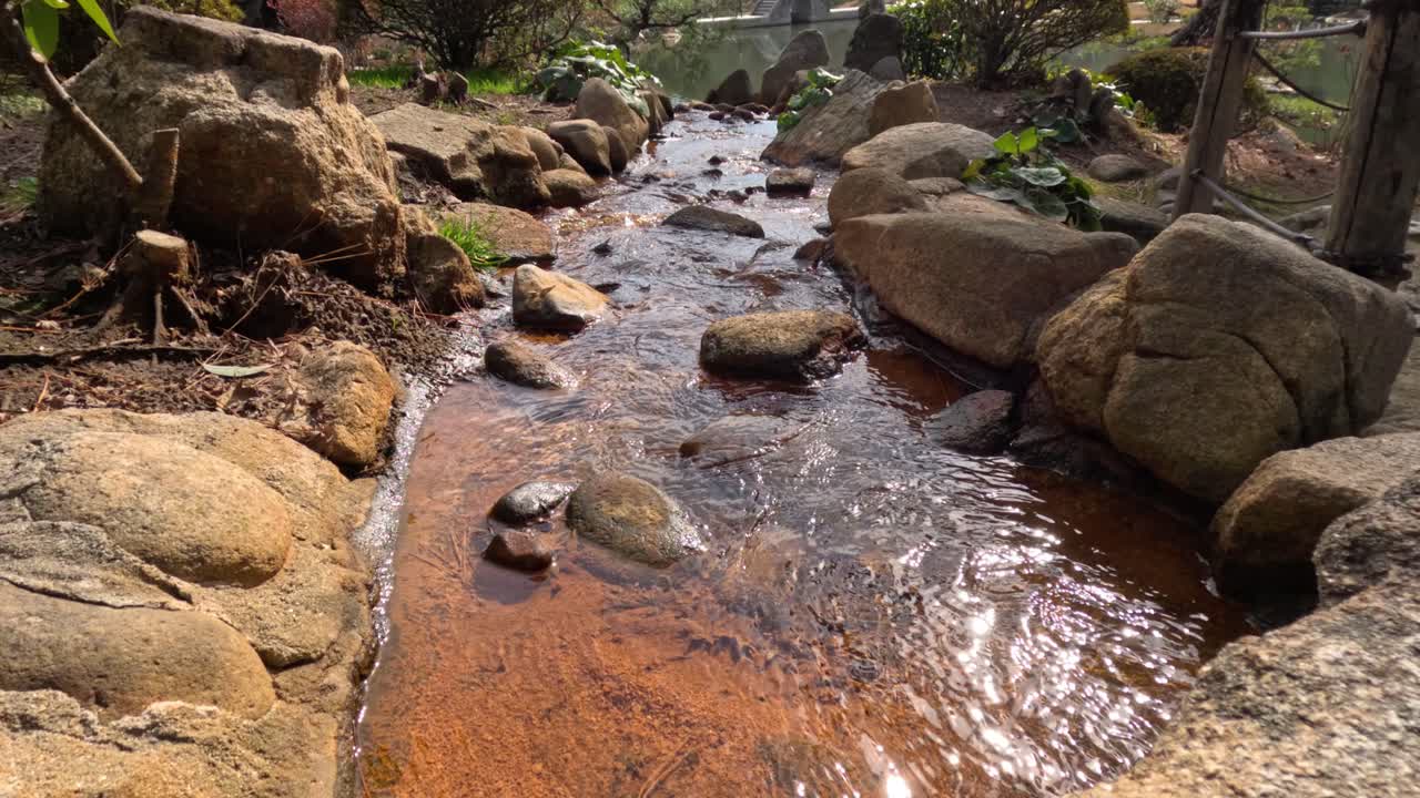 una suave corriente de agua serpentea a través de un lecho rocoso