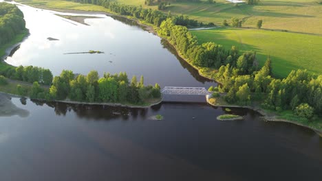 Ein-Zeitraffer,-In-Dem-Sich-Die-Kamera-Von-Einer-Eisenbahnbrücke-Entfernt,-Die-Einen-Breiten-Blauen-Fluss-überquert