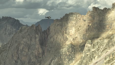 helicopter flying over the edge of a mountain french alps