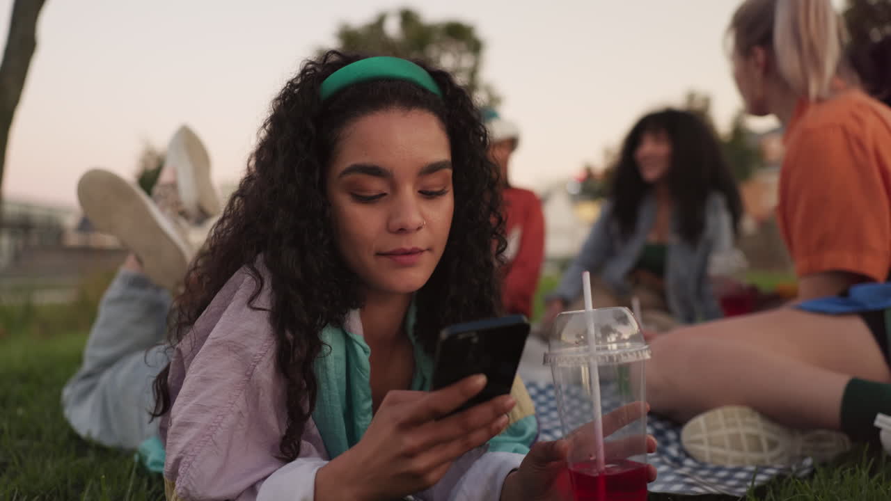 Happy woman, phone and relax with friends at park