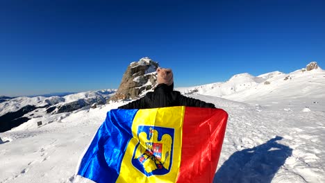 girl running with the romanian flag on top of the bucegi mountains, towards the sphinx rock in romania - slow motion shot