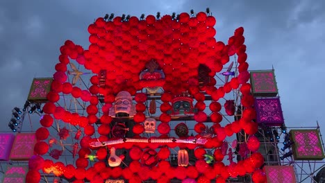 vibrant red day of the dead altar with skulls and decorations set against a moody sky
